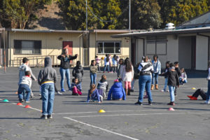 Adult at recess reminds students of boundaries during tag game